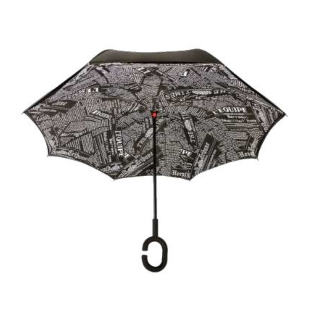 Open Knirps reversible umbrella has c-shaped handle with newsprint article design