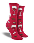 Socks in red with wine glasses, chocolate, and truffles. 