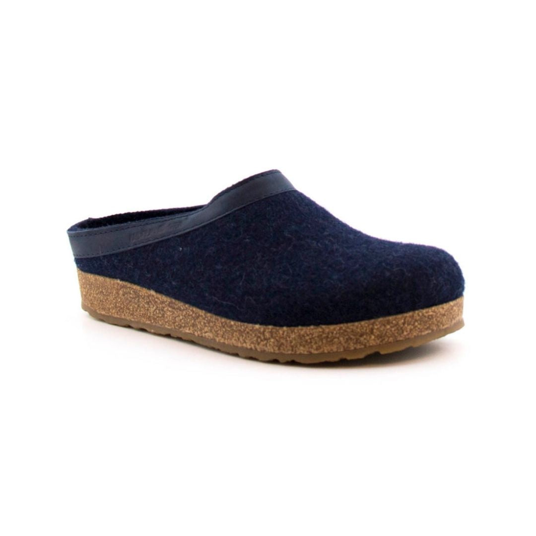 Navy wool slide slipper with leather band and Haflinger tag on outside. Cork midsole and brown outsole.