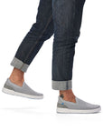 Man in jeans wearing grey slip on mesh shoe with heel pull tab and white outsole