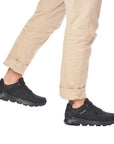Man in beige pants wearing black R-Evolution lace-up sneakers.