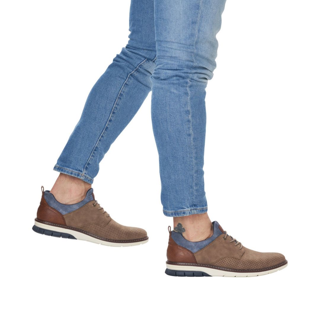 Man in jeans wearing brown slip on sneakers with faux elastic laces.