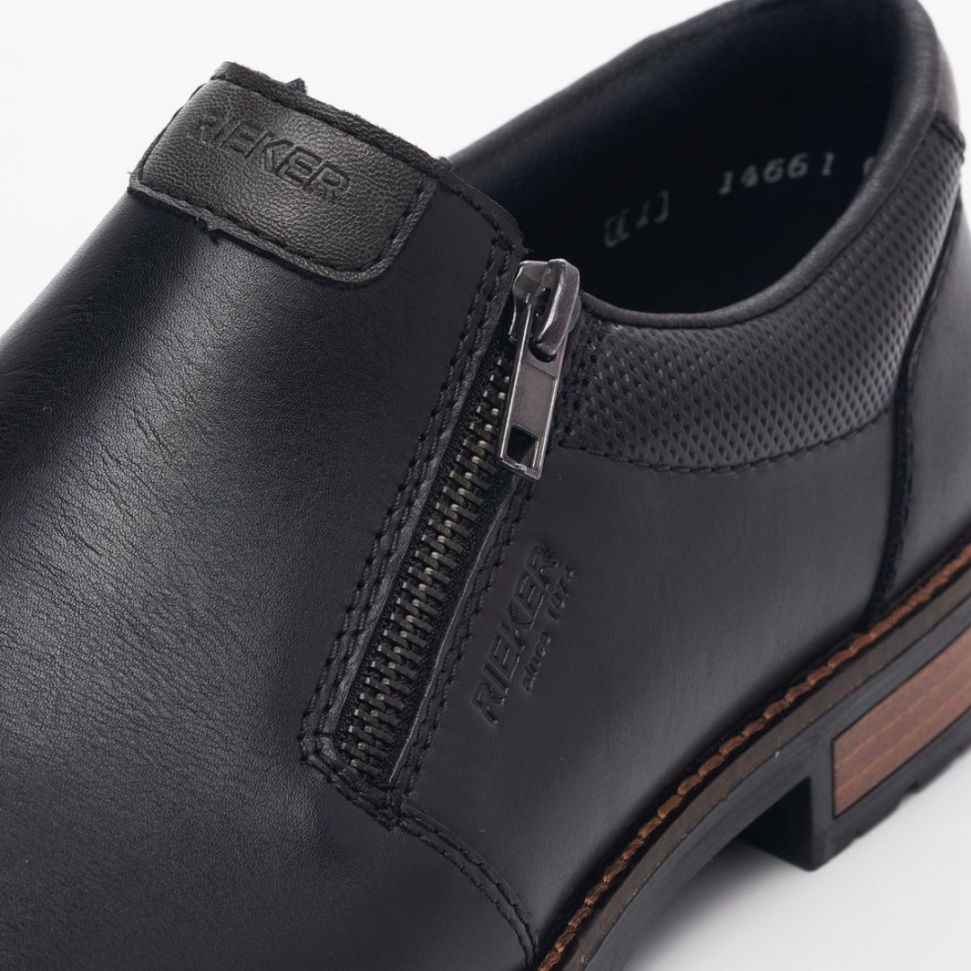 Black dress shoe with zipper closure and Rieker logo on instep.