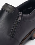 Black dress shoe with zipper closure and Rieker logo on instep.