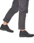 Man in grey pants wearing ankle boots with Velcro closure.