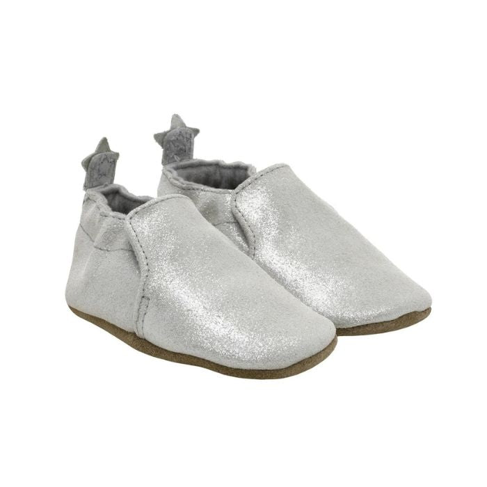 Silver glittery baby shoes with brown outsoles and stars on the heels.