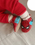 Baby wearing red and blue Spiderman baby leather shoes.