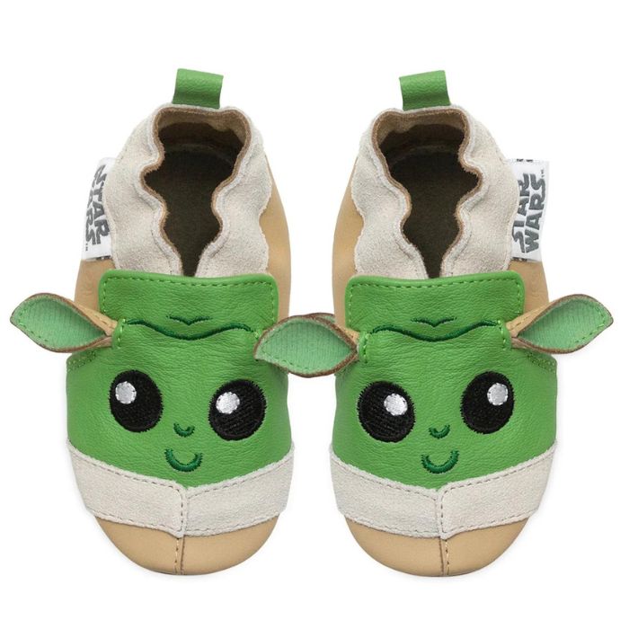 Brown and green leather baby shoes that look like Baby Yoda. Star Wars logo tags sewn on outside.