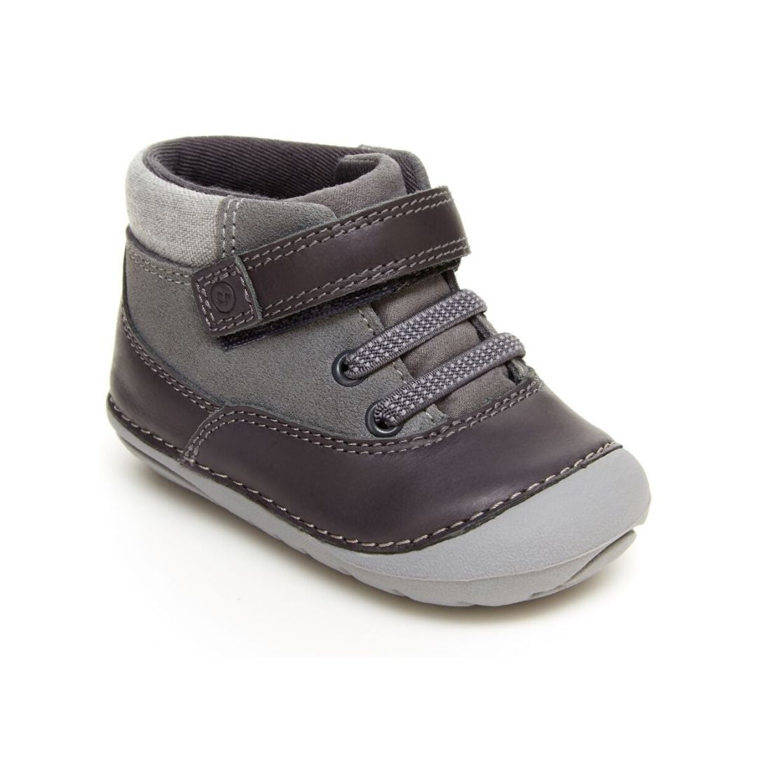 Grey leather ankle boot with Velcro strap and light grey outsole.