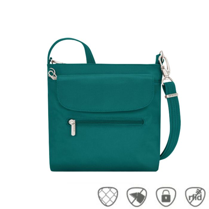 Teal crossbody bag with front flapped pocket and front horizontal zippered pocket. Bag has silver zippers and clasps