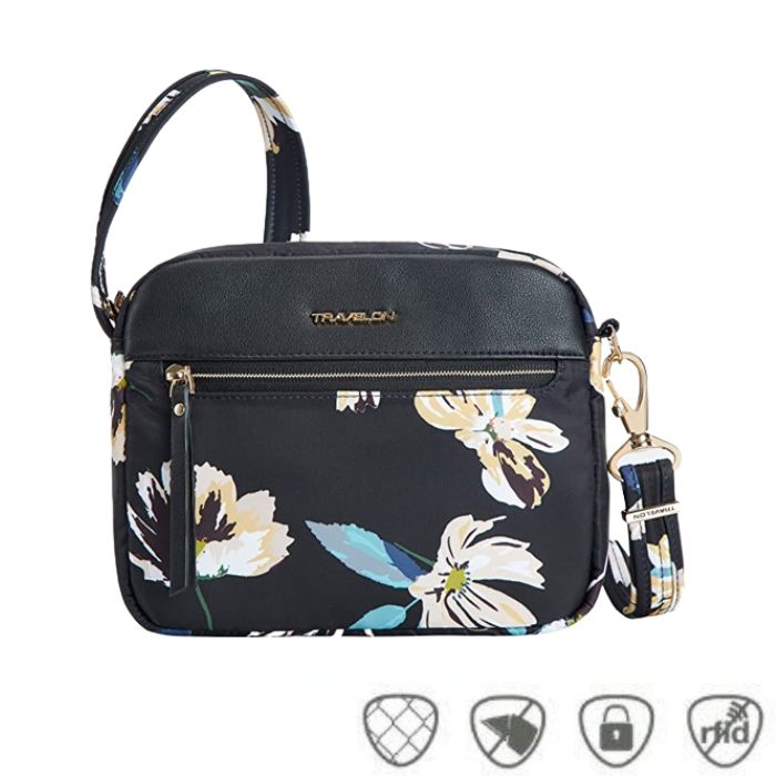 Black floral crossbody bag with gold Traelon emblem. Horizonal gold zipper is on the front.