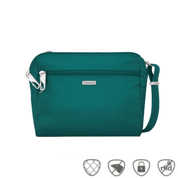 Small teal crossbody bag with silver Travelon logo in center below full length zipper.