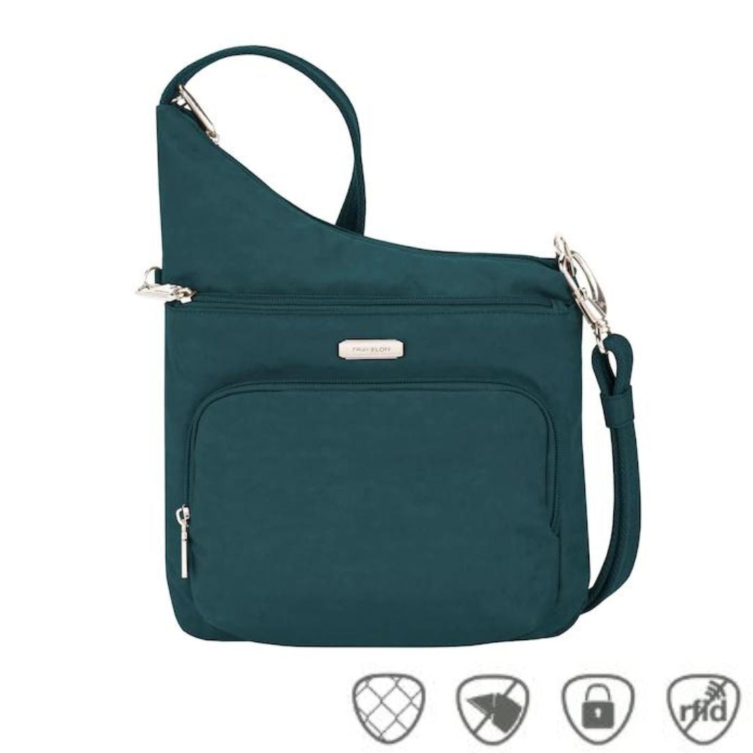 Teal crossbody bag with horizontal zippered pocket and zippered pouch pocket. Silver Travelon logo emblem on front.