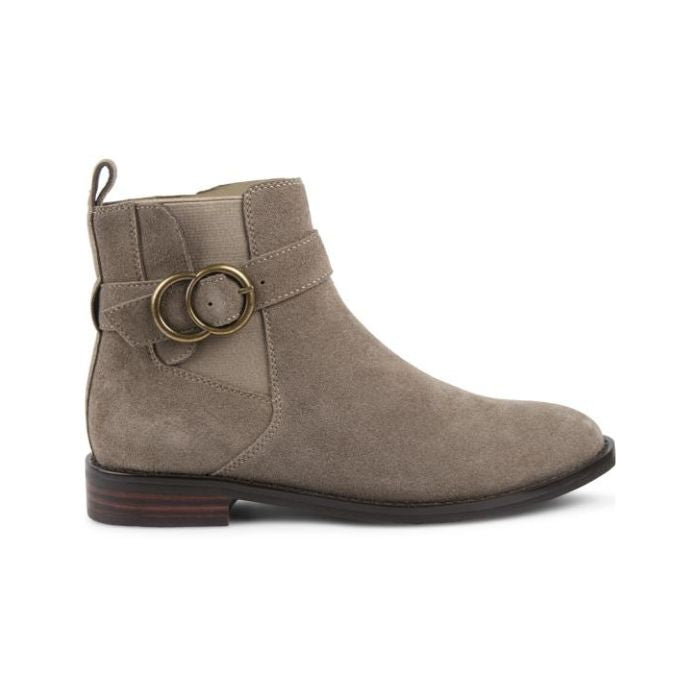Taupe suede ankle boot with brass circle buckles and low stacked heel.