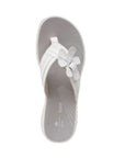 Top view of white flip flop with floral detail on strap. Clarks logo in white on insole.