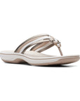 Bronze, beige and white strappy thong sandal with white midsole and brown outsole.