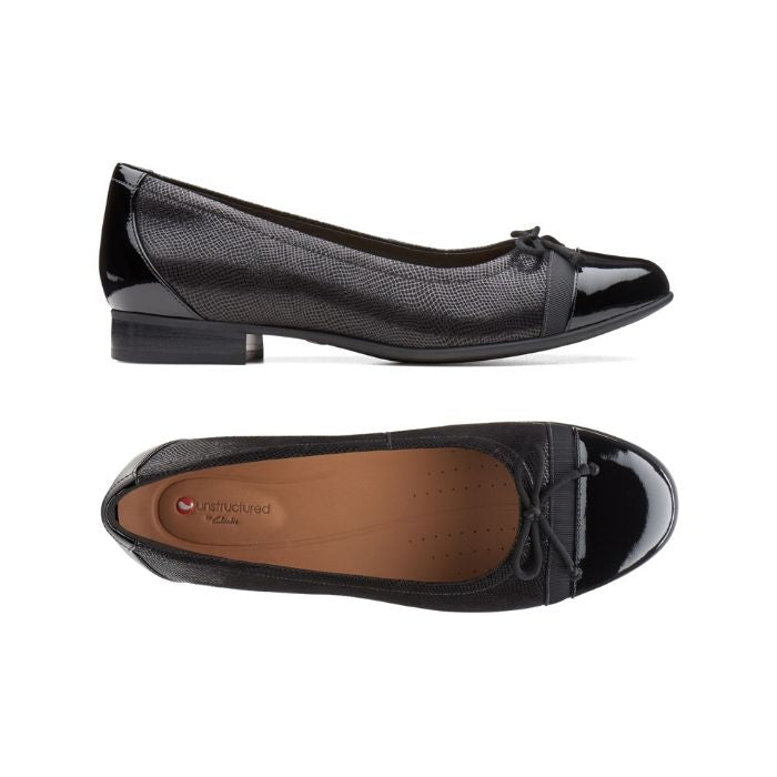 The textured black side of the Cap 2 flat by Clarks has a shiny slight  heel and shiny toe and the top has a bow at the shiny toe and tan footbed.
