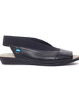 Black leather sandal with low wedge elastic backstrap.