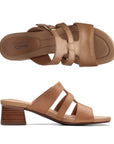 Top and side view of tan leather slide sandal with gold buckle and brown stacked heel. Clarks logo printed on heel.