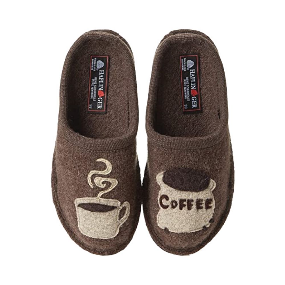 A pair of brown slide slippers with a coffee mug and coffee bean bag detailing. Haflinger logo on footbed&#39;s heel.