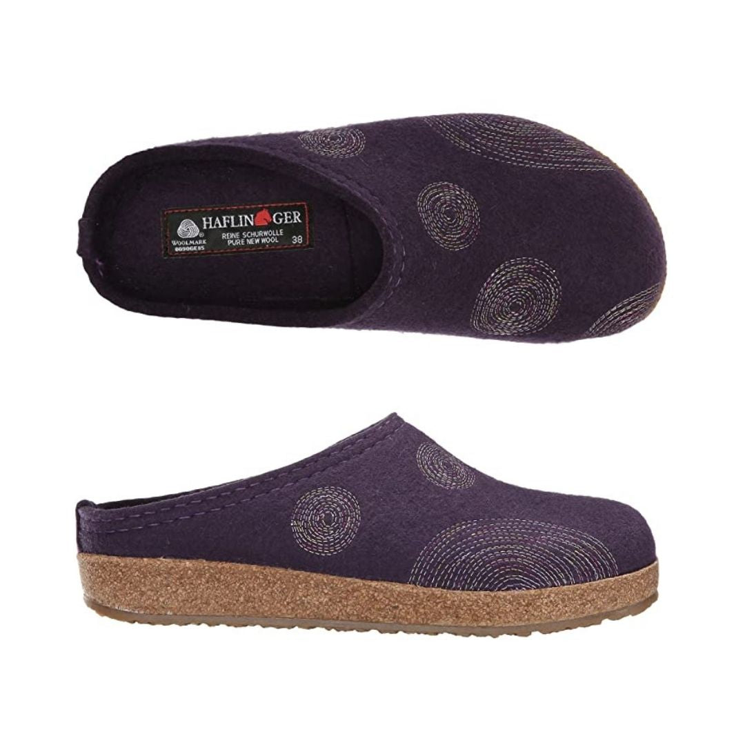 Top and side view of purple wool slipper with circle stitching details, brown cork midsole and black outsole. Haflinger logo printed on footbed
