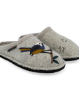 Grey wool slippers with a black outsole. One slipper has a blue and yellow bird on a twig, and the other has small bird footprints in black thread. 