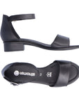 Black sandal that has ankle strap with silver buckle and low stacked heel. Remonte logo printed on footbed.