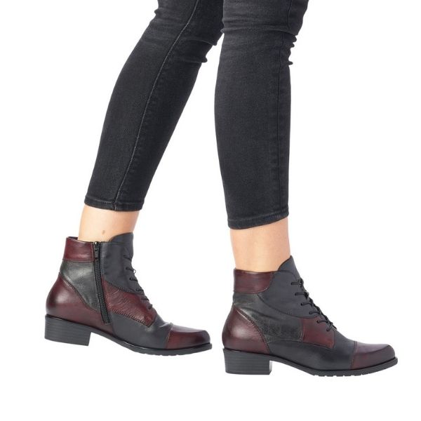 Black jeans wearing multi-colored patchwork ankle boot with lace closure.