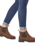 Legs in cuffed jeans wearing brown Chelsea boot with dark brown elastic goring.