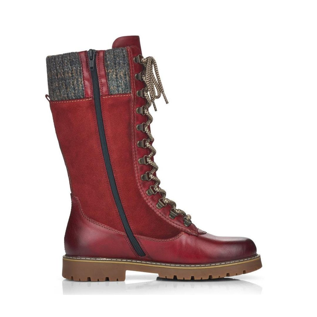 Mid-height red leather winter boot with lace closure, yarn cuff, full length zipper and brown outsole with grip.