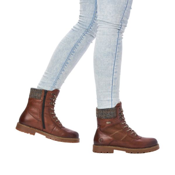 Women wearing jeans and  brown  mid winter boots with laces and side zipper.