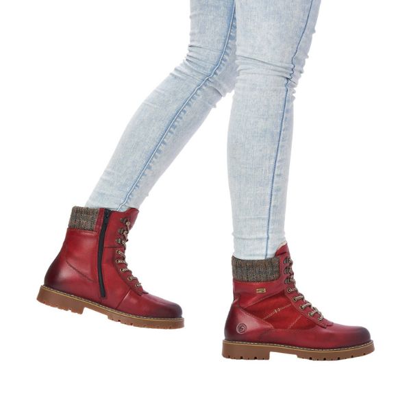 Women wearing jeans and  red mid winter boots with laces and side zipper.
