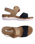 Pair of Backstrap Sandals in tan and navy with oversized buckle, tan Remonte logo'd footbed, adjustable straps, faux cork midsole and white outsole.