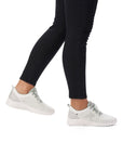 Women wearing grey mesh sneaker with laces and white outsole.