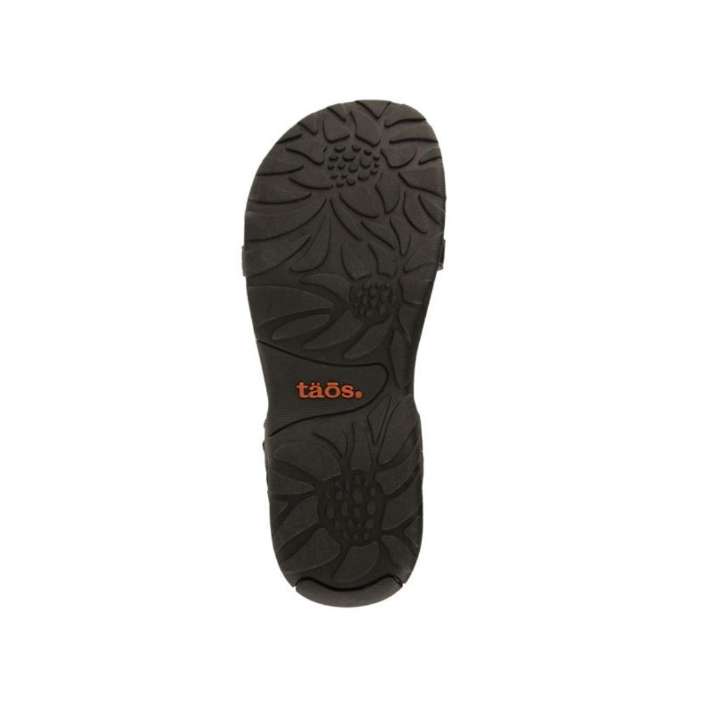 Black outsole with floral style tread. Orange Taos logo in center.