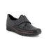 Black slip-on shoe with spotted print embossed design, Velcro strap across vamp and wedge heel.