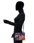 Black human silhouette showcasing the navy leather crossbody bag with vibrant floral hand painted pattern.