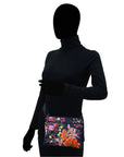 Black human silhouette showcasing the navy leather bag with vibrant floral hand painted pattern.