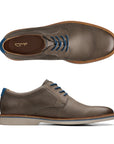 Top and side view of taupe leather dress shoe with blue laces and off white outsole. Clarks logo on heel of insole.