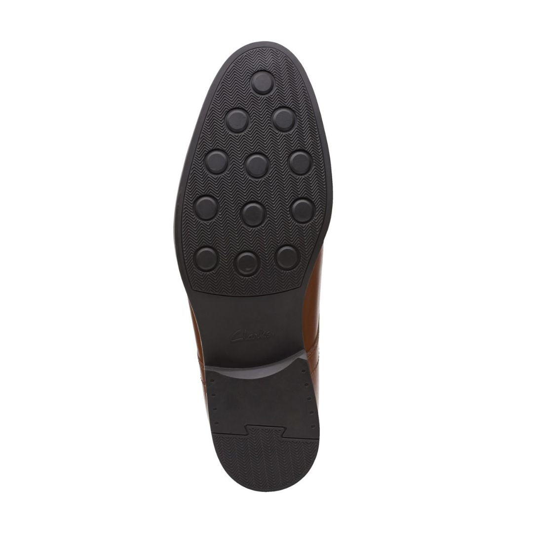 Black rubber outsole with circle pattern and Clarks logo on center.